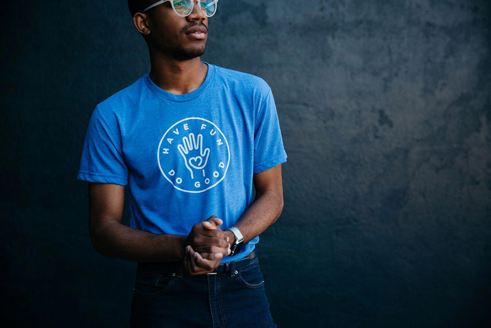 Man in blue shirt with glasses and clasped hands